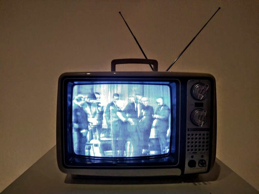 Photo by Bruna Araujo - Canadian Ad Insider black crt tv turned on on white table
