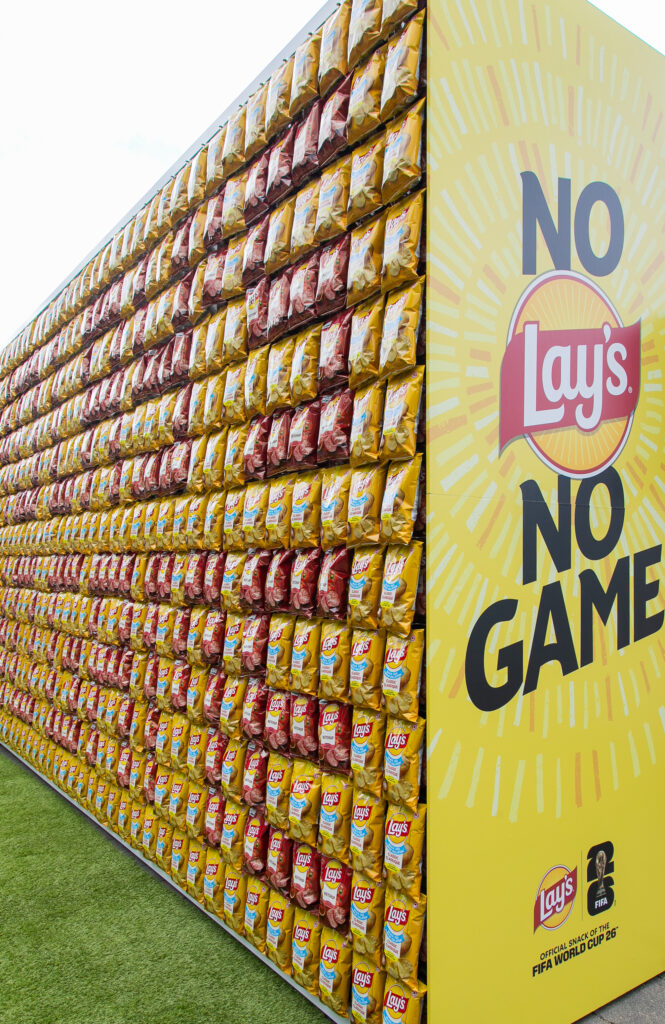 Wall of stacked Lay's potato chip bags beside a bright yellow display that reads 'NO GAME' with the Lay's logo and FIFA branding.