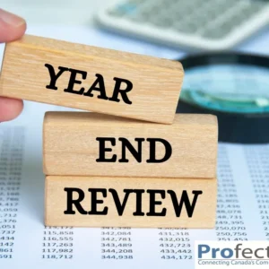 Wooden blocks spell 'YEAR END REVIEW' laid over a financial document.