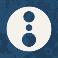 White circular badge containing three blue dots stacked vertically on a textured blue background.