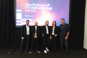 Five professionals posing for a photo on a conference stage in front of a backdrop that reads'The Future of TV Advertising Canada'.